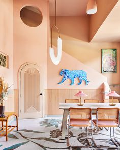 the dining room is decorated in pink and blue with an animal sculpture on the wall