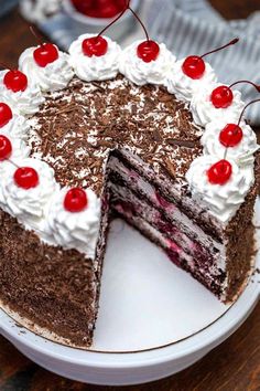 a chocolate cake with white frosting and cherries