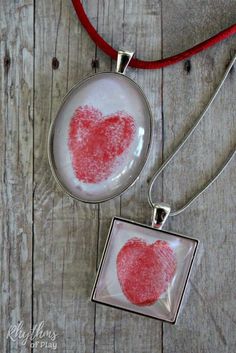 two necklaces that have been made to look like heart prints on glass and red cord