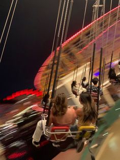 two people ride on a merry go round at night