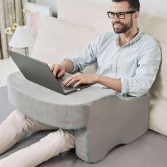 a man sitting on a couch using a laptop