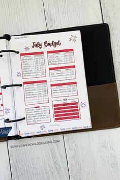 an open planner book sitting on top of a wooden table