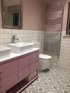 a bathroom with two sinks, a toilet and a towel rack in the middle of it