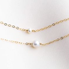 Our freshwater pearl necklace is the most classic necklace we have. A dainty, authentic pearl is wire-wrapped into a necklace. Choose from Gold filled or sterling silver. The perfect tiny addition to any outfit! DETAILS Necklace length: Small pearl - 14" with 2" extender Big pearl - 16" with 2" extender Authentic freshwater pearl Gold filled -or- sterling silver chain, wire, & findings Matching earrings: Dainty Pearl Earrings, Pearl Hoop Earrings, or Pearl Threader Earrings Matching bracelet Pearl Threader Earrings, Simple Pearl Necklace, Single Pearl Necklace, Detailed Necklace, Classic Necklace, Gold Pearl Necklace, Freshwater Pearl Bracelet, Freshwater Pearl Necklace, Everyday Necklace