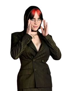 a woman with red hair wearing a suit and glasses posing for the camera while holding her hands up to her face