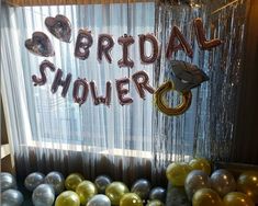 balloons and streamers are set up in front of the bridal shower sign