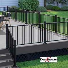 a deck with black railing and chairs on it