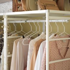 the closet is organized with clothes and handbags on racks, including purses and bags