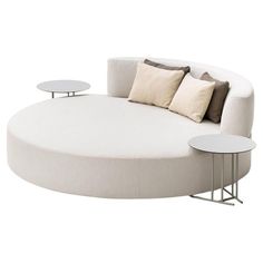 a round couch with two tables on each side