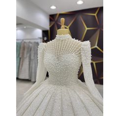 a dress on display in a store with lots of white beading and sequins