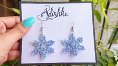 a pair of blue snowflake earrings sitting on top of a card