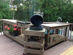 an outdoor kitchen on a deck with potted plants