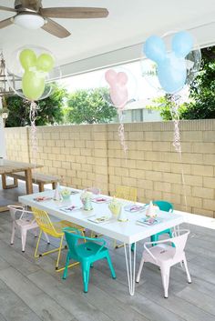 a table and chairs with balloons attached to the ceiling