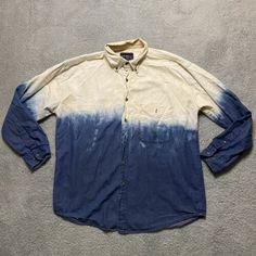 a blue and white shirt sitting on top of a carpet