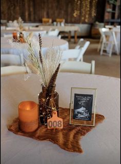 an arrangement of flowers and candles on a table