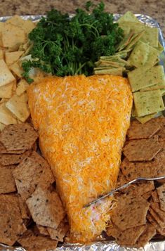 a cheese and cracker platter with tortilla chips, celery, and parsley