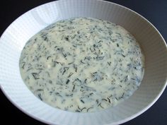 a bowl filled with white sauce on top of a table