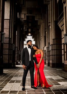 a man and woman in formal wear posing for a photo on a tiled floor with columns