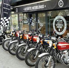 a row of motorcycles parked in front of a motorcycle shop