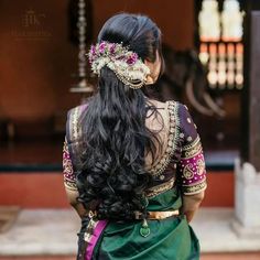 a woman with long black hair wearing a green sari