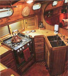 the inside of a boat with an oven, sink and stove top in it's center