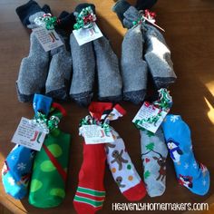 several pairs of socks with tags on them are sitting on a wooden table and there is also an ornament hanging from the sock