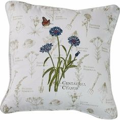 a white pillow with blue flowers on it and a butterfly flying over the flower stems