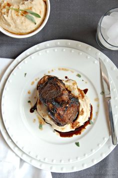 a white plate topped with meat and mashed potatoes