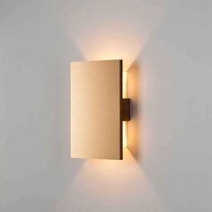 a wall mounted light on the side of a white wall