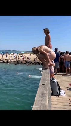 some people are standing on a pier by the water