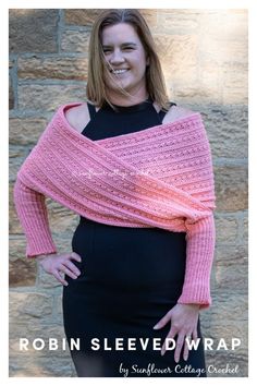 a woman standing in front of a brick wall wearing a pink knitted shawl