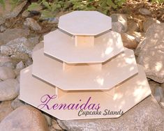 three tiered cake stand sitting on top of some rocks