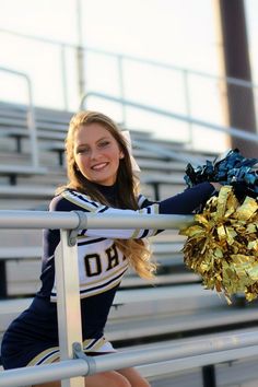 a cheerleader is posing on the bleachers