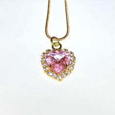 An elegant pink crystal heart on a delicate gold chain. Pink Heart-shaped Clavicle Chain Jewelry, Pink Heart-shaped Jewelry With Clavicle Chain, Pink Heart Necklace On Clavicle Chain, Pink Heart Pendant Necklace With Clavicle Chain, Pink Heart Necklace With Clavicle Chain For Valentine's Day, Valentine's Day Pink Heart Necklace With Clavicle Chain, Pink Crystal Heart Pendant Jewelry, Pink Heart Pendant Clavicle Necklace, Pink Gold-plated Jewelry With Adjustable Chain