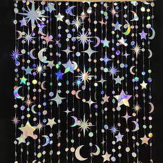 a black background with stars and crescents hanging from it's sides, all in different colors