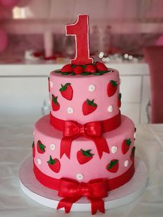 a three tiered cake with strawberry decorations on it