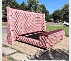 a large pink bed sitting on top of a sidewalk