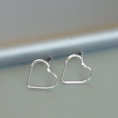 IMPORTANT **Please go through all the pictures i have posted for a listing with a ruler, on a model, on my hand, to get an exact idea of the actual size of the item. ONE PAIR of sterling silver heart ear studs. Dimensions: 10 x 9 Weight: 0.52 gm These earrings are made of 925 hypoallergenic sterling silver. Please note this price is for ONE PAIR only. All my pieces are sent in a gift box. I can include a personal message from you if needed You are welcome to contact me at... bhavnakwintra1956@gm Earrings Minimalist, Silver Accessories, 925 Silver Jewelry, Feather Earrings, Fun Earrings, Sterling Silver Heart, Ear Jewelry, Minimalist Earrings, Ear Studs