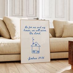 a blue and white sign sitting on top of a wooden floor next to a couch