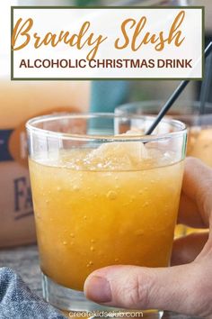 a hand holding a glass filled with alcohol and the words brandy slush alcoholic christmas drink