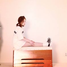 a woman sitting on top of a wooden bed