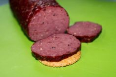 a close up of some food on a green surface with a cracker in the foreground