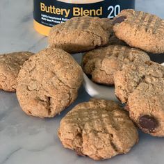 chocolate chip cookies and peanut butter on a counter next to a jar of buttery blend