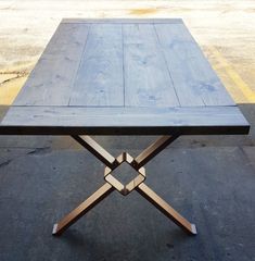 a wooden table sitting in the middle of a parking lot with no one around it