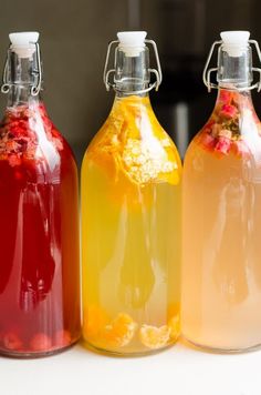 three bottles filled with liquid sitting on top of a table