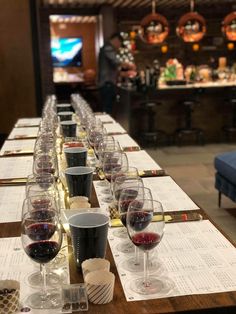 wine glasses are lined up on a long table