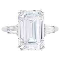 This luxurious ring features a 5 carat emerald cut diamond, certified by the GIA. The diamond exhibits an D color grade and VVS1 clarity, ensuring exceptional brilliance and clarity. With an excellent polish and symmetry, the diamond's cut enhances its elegant appearance. The absence of fluorescence ensures a pure and natural glow. Set in a sophisticated platinum band with two tapered baguette side stones, this ring embodies timeless elegance and refinement. Harry Winston Emerald Ring, Sapphire Solitaire Ring, Emerald Cut Diamond Engagement, Ring Inspo, Gia Certificate, Contemporary Engagement Rings, Emerald Cut Diamond Ring, Future Engagement Rings, Solitaire Rings