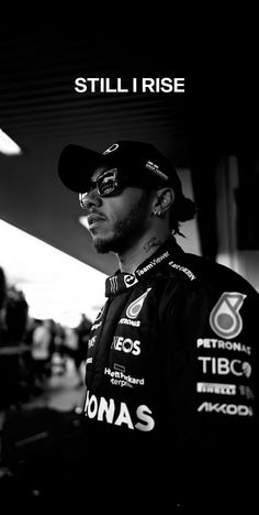 a man wearing a hat and glasses standing in front of a building