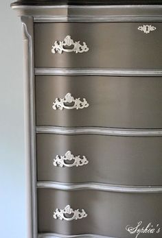 an antique dresser painted in silver and white