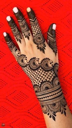 a woman's hand with henna tattoos on it